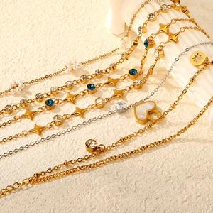 Bracciale dorato con perle cuori e cristalli blu su supporto in pietra chiara