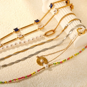 Set di collane dorate e bracciali di perle su sfondo minimalista con colonne romane