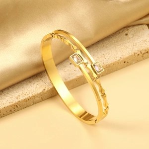 Detail of 18K gold-plated double-layer bangle featuring wavy design and zircon stones
