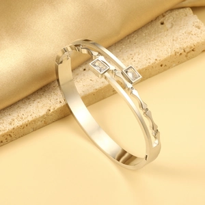 Detail of silver double-layered bangle with wavy edges and inlaid rectangular crystals