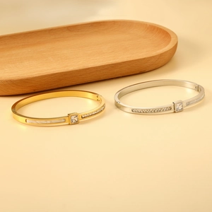 Detail of 18K gold and silver open bangles with square crystal and shell inlay detail