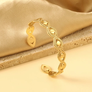 Détail d'un bracelet ouvert plaqué or avec motif feuille vintage et finition polie