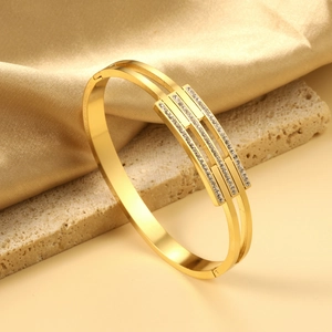 Macro detail of 18K gold-plated double-layer geometric bangle with pave-set rhinestones
