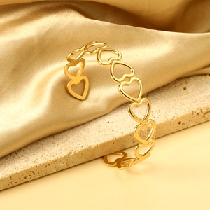 Vue détaillée du bracelet jonc doré avec motifs continus en forme de cœurs ajourés