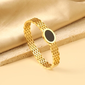 Detailed view of hollow mesh gold bracelet featuring a black oval center stone inlay