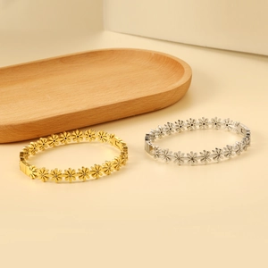 Detailed view of daisy-shaped bracelets in gold and silver finish with crystal centers