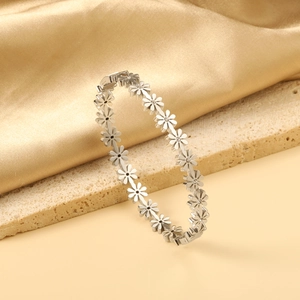 Polished silver daisy link bracelet with white crystals on a beige stone and silk base