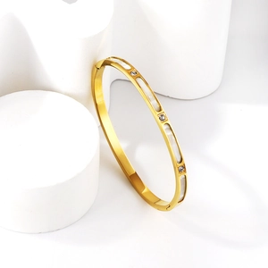 Detail of 18K gold-plated bangle featuring white mother-of-pearl and inlaid zircons