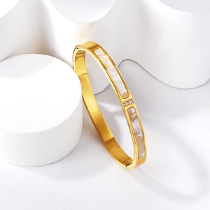 Detail of 18K gold-plated bangle featuring white shell inlay and three small zircon stones