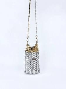 Detail of metallic chainmail texture with silver sequins and golden shoulder strap chain