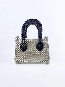 Detail of silver beaded mini handbag featuring contrasting black pearl top handles