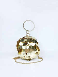 Detail of golden spherical evening bag featuring layered sequins and crystal ring handle
