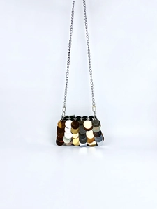 Detailed view of shimmering layered gold and silver sequins on a luxury chain handbag