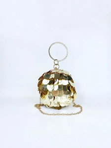 Close-up of golden spherical evening bag featuring large sequins and rhinestone handle
