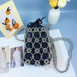 Detailed view of silver beaded hollow handbag with black satin drawstring lining pouch