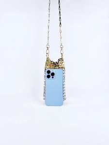 Detail of handmade woven metal chain phone bag with gold and silver link texture