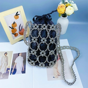 Close-up of woven silver bead mesh and black drawstring inner pouch of shoulder bag