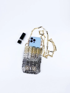 Macro shot of silver and gold metal sequins phone bag with a chain shoulder strap
