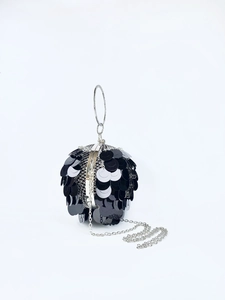Close-up of a spherical evening bag with black metallic sequins and silver ring handle