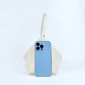 Macro shot of handmade white pearl beaded handbag showing geometric woven texture