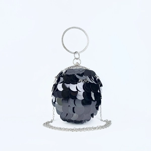 Detail of spherical evening bag with black sequins, crystal ring handle, and silver chain