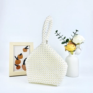 Detail of hand-woven pearl handbag featuring premium white beads and trapezoid structure