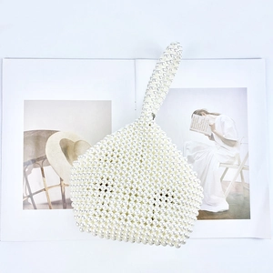 Detail of handmade white pearl beaded handbag with unique geometric weave on a fashion magazine