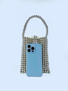 Silver beaded metallic handbag with drawstring lining and a smartphone for size reference
