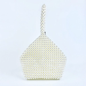 Detailed close-up of handmade white pearl beaded bag with unique polygonal shape and handle