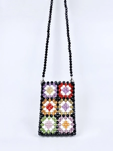 Detail of colorful handmade beaded floral granny square pattern on a vintage shoulder bag