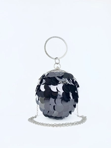 Detail of spherical clutch bag featuring black sequins and rhinestone-studded metal handle