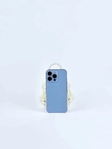 Detailed macro view of a handmade white pearl beaded handbag with light blue smartphone inside