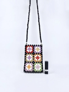 Detailed shot of handmade colorful beadwork pattern and metal clasp on crossbody phone bag