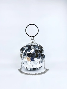 Close-up of silver spherical evening bag with large metallic sequins and round handle