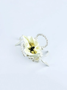 Detail of elegant satin drawstring bag with white faux pearl beads and circular pearl handle