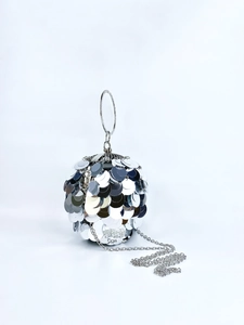 Detailed view of silver sequin spherical evening bag with metal ring handle and chain
