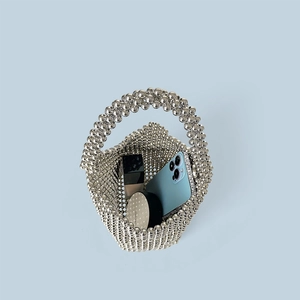 Detail of silver beaded handbag showing storage capacity for a smartphone and cosmetics