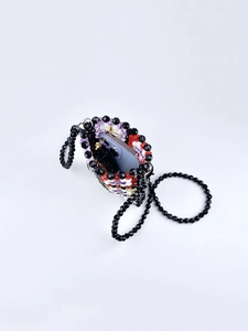 Macro shot of colorful beaded shoulder bag showing interior space for a smartphone
