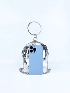 Spherical silver sequin evening bag size comparison with a smartphone on white background
