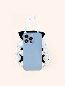 Fashionable white beaded bucket bag with black lining shown with a phone for size scale
