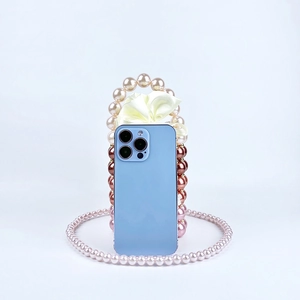 Detail of beaded mobile case with gradient pearls and a large white satin bow accent