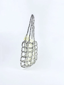Macro detail of silver beaded woven handbag with satin drawstring lining and mesh structure