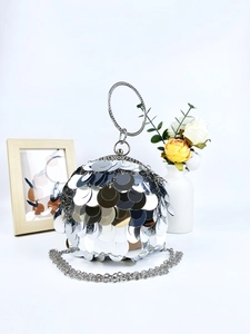 Silver spherical evening bag with metal sequins, rhinestone handle, and chain strap