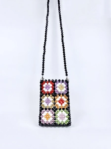 Detail of colorful handmade beaded crossbody bag with vibrant floral crochet patterns