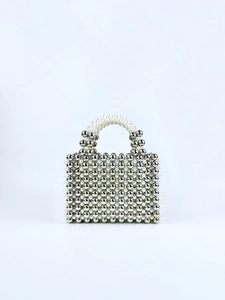 Detail of handmade beaded handbag with silver metal beads and white pearls in square shape