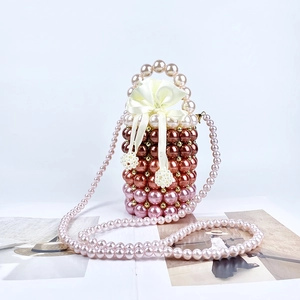 Detail of handmade pearl beaded bucket bag with satin drawstring liner and bow