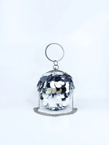 Detail of silver spherical evening bag with large reflective sequins and diamond ring handle