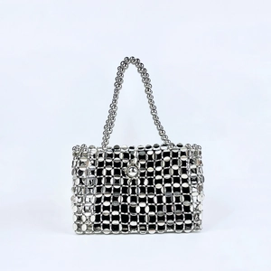 Close-up of shiny silver metallic discs and beaded handle on a handcrafted bag