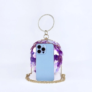 Detail of purple sequin spherical evening bag with gold metal handle and chain