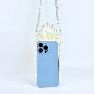 Handmade pearl bead bucket bag next to a smartphone for clear size comparison